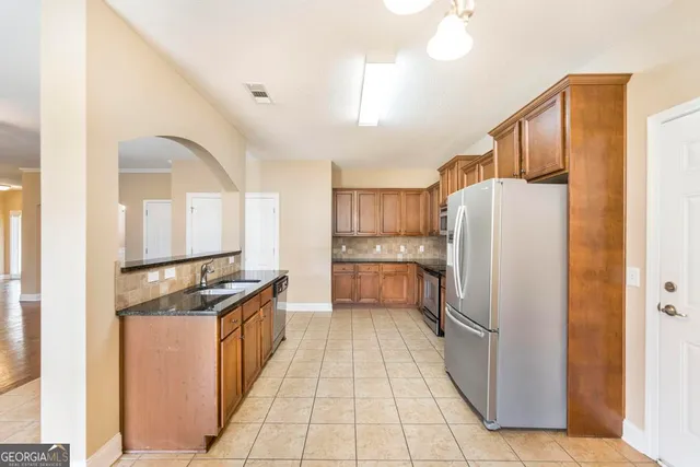 a kitchen with stainless steel appliances granite countertop a refrigerator and a stove