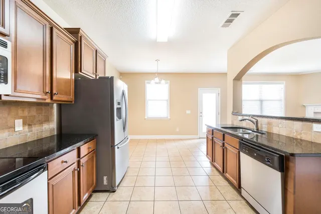 a kitchen with stainless steel appliances granite countertop a sink stove and refrigerator