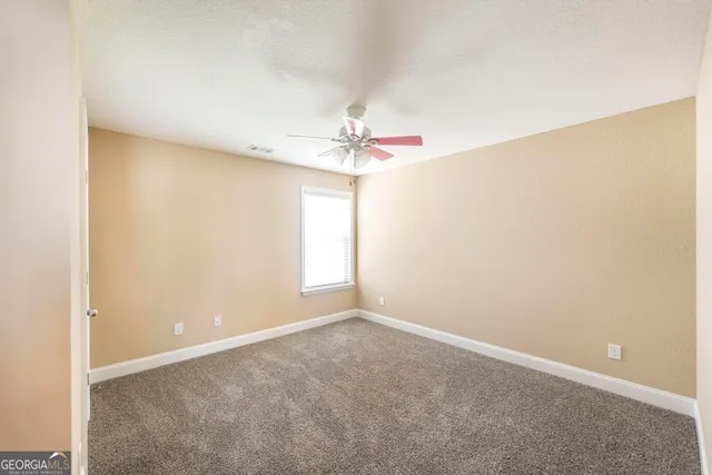 a view of a room with a ceiling fan and a window