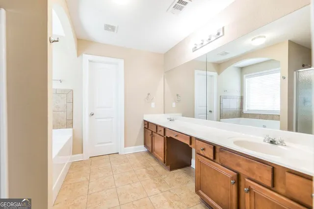 a spacious bathroom with a granite countertop sink and a mirror