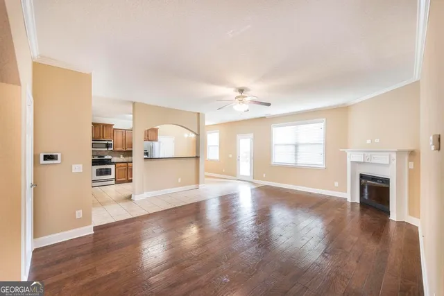 a view of empty room with wooden floor and fireplace