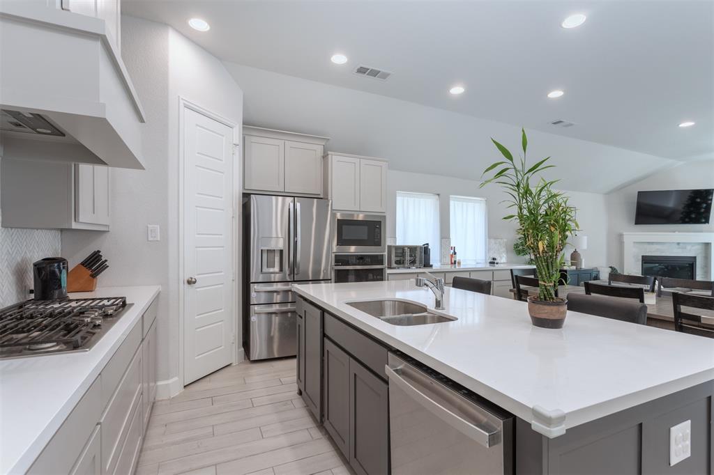 9110 Copperhead Road Little Elm, TX 75068 - Photo 9 of 35 a kitchen with stainless steel appliances a sink a stove and refrigerator