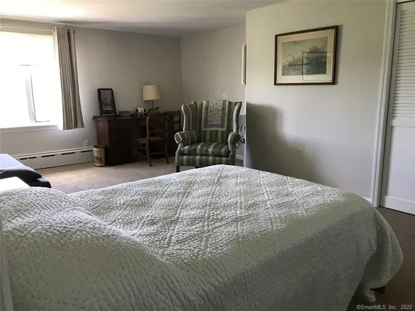 a bed sitting in a bedroom next to a window with tv