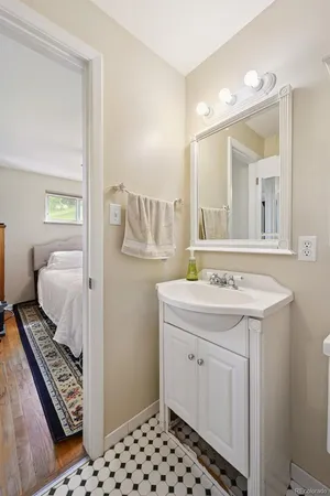 a en suite bathroom with a granite countertop sink and a mirror