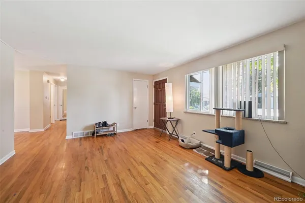 a view of a room with a large window and wooden floor