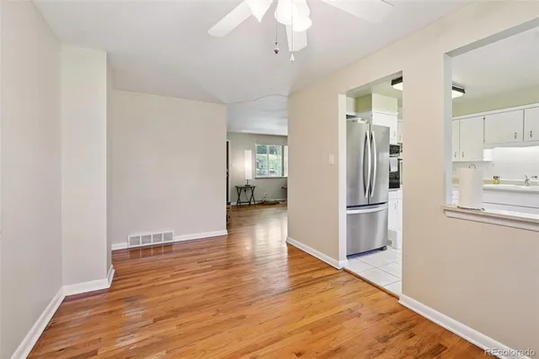 a view of a kitchen with refrigerator and wooden floor