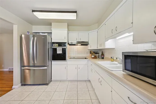 a kitchen with a refrigerator sink and cabinets