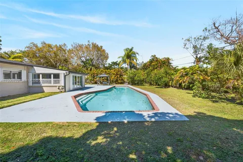 a view of a house with swimming pool and a yard