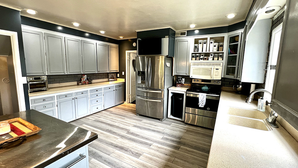 644 Genesee Avenue Morrison, IL 61270 - Photo 14 of 52 a large kitchen with stainless steel appliances a stove a sink dishwasher a refrigerator and cabinets with wooden floor