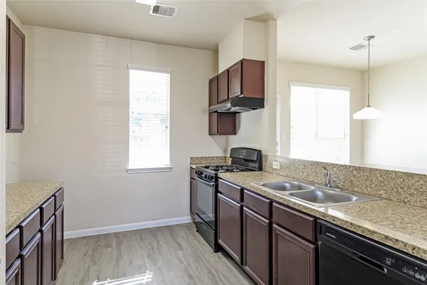 a kitchen with a sink stove top oven and cabinets