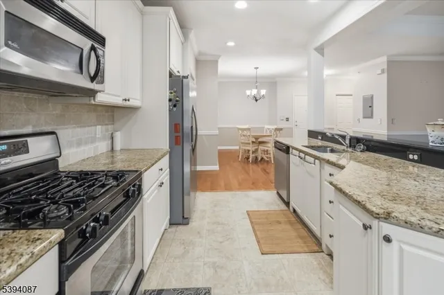 a kitchen with granite countertop a sink stove and cabinets
