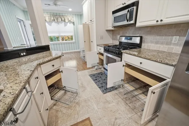 a kitchen with granite countertop a stove a sink and a microwave