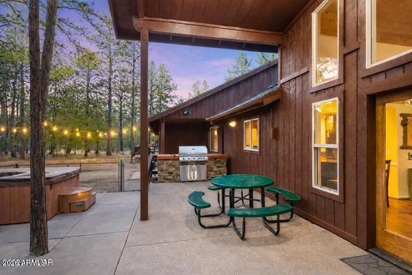 a view of a patio with table and chairs with wooden fence