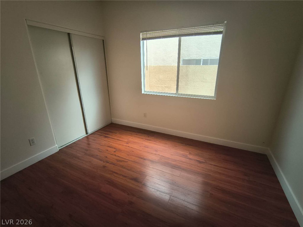 9725 Pima Point Avenue Las Vegas, NV 89147 - Photo 15 of 35 Wood flooring and a spacious closet define this inviting bedroom.