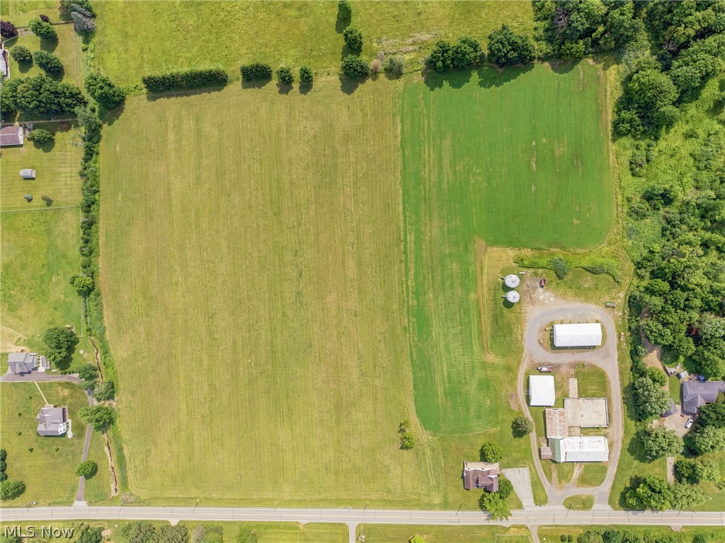 11513 Kile Road Chardon, OH 44024 - Photo 27 of 48 Expansive agricultural property featuring cultivated fields, wooded borders, multiple outbuildings, and two visible grain bins