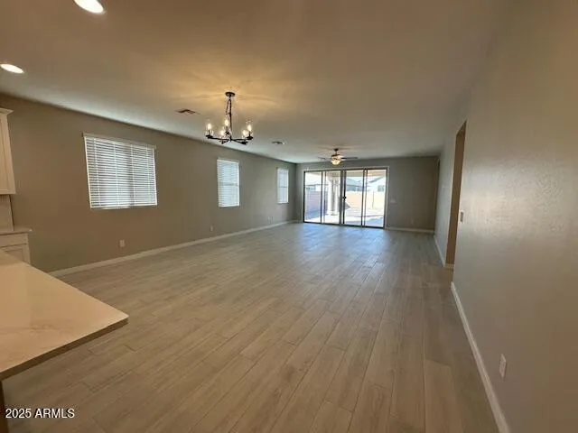 a view of kitchen with granite countertop cabinets and refrigerator
