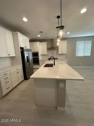 a kitchen with white cabinets and black appliances