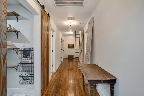 a view of a hallway with wooden floor and staircase