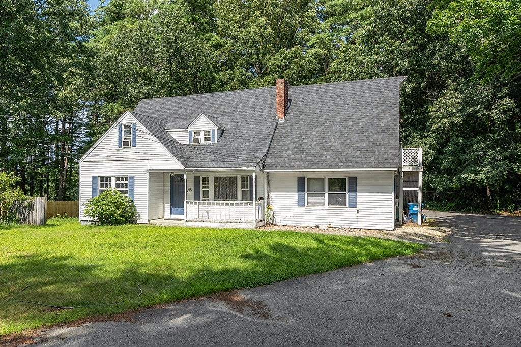 a front view of a house with a yard and trees