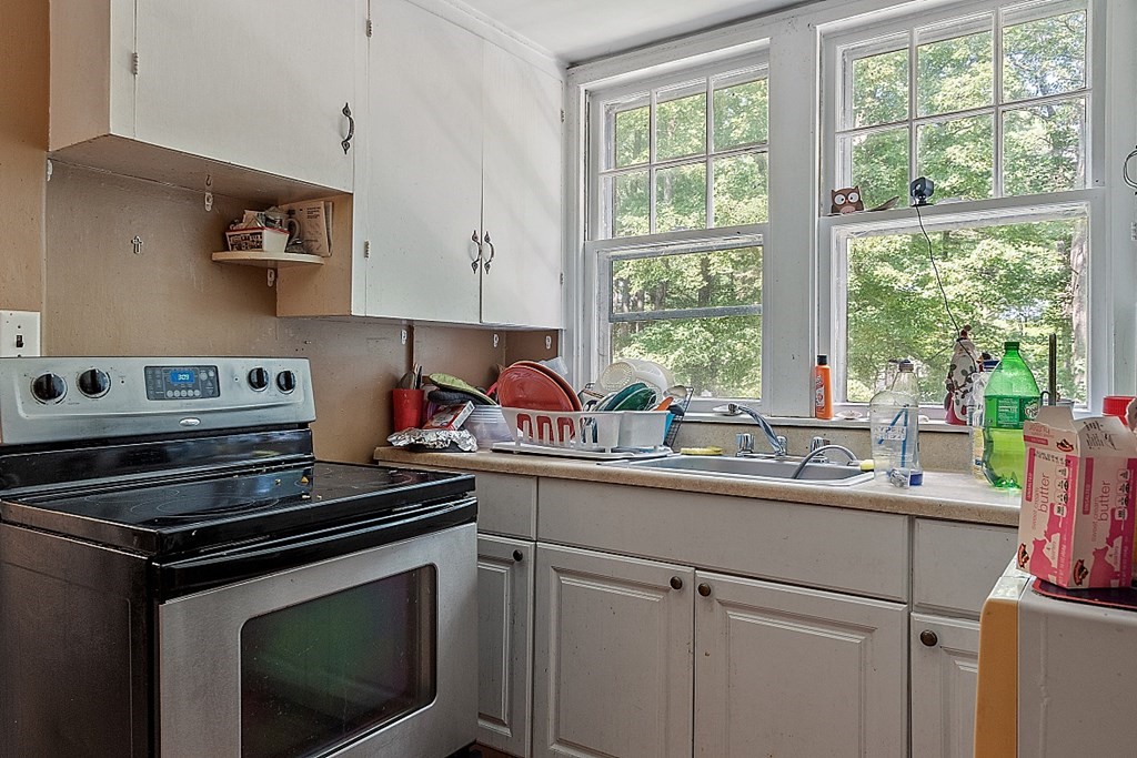 55 Sylvan Road Lancaster, MA 01523 - Photo 17 of 22 a kitchen with a sink stove and cabinets