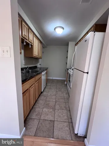 a kitchen with a refrigerator a stove top oven and a sink