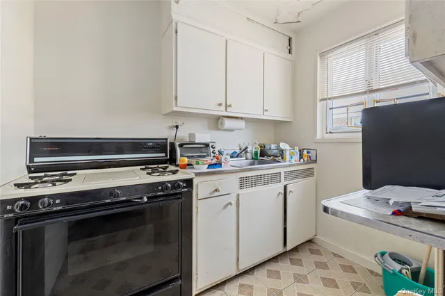 a kitchen with a stove and white cabinets