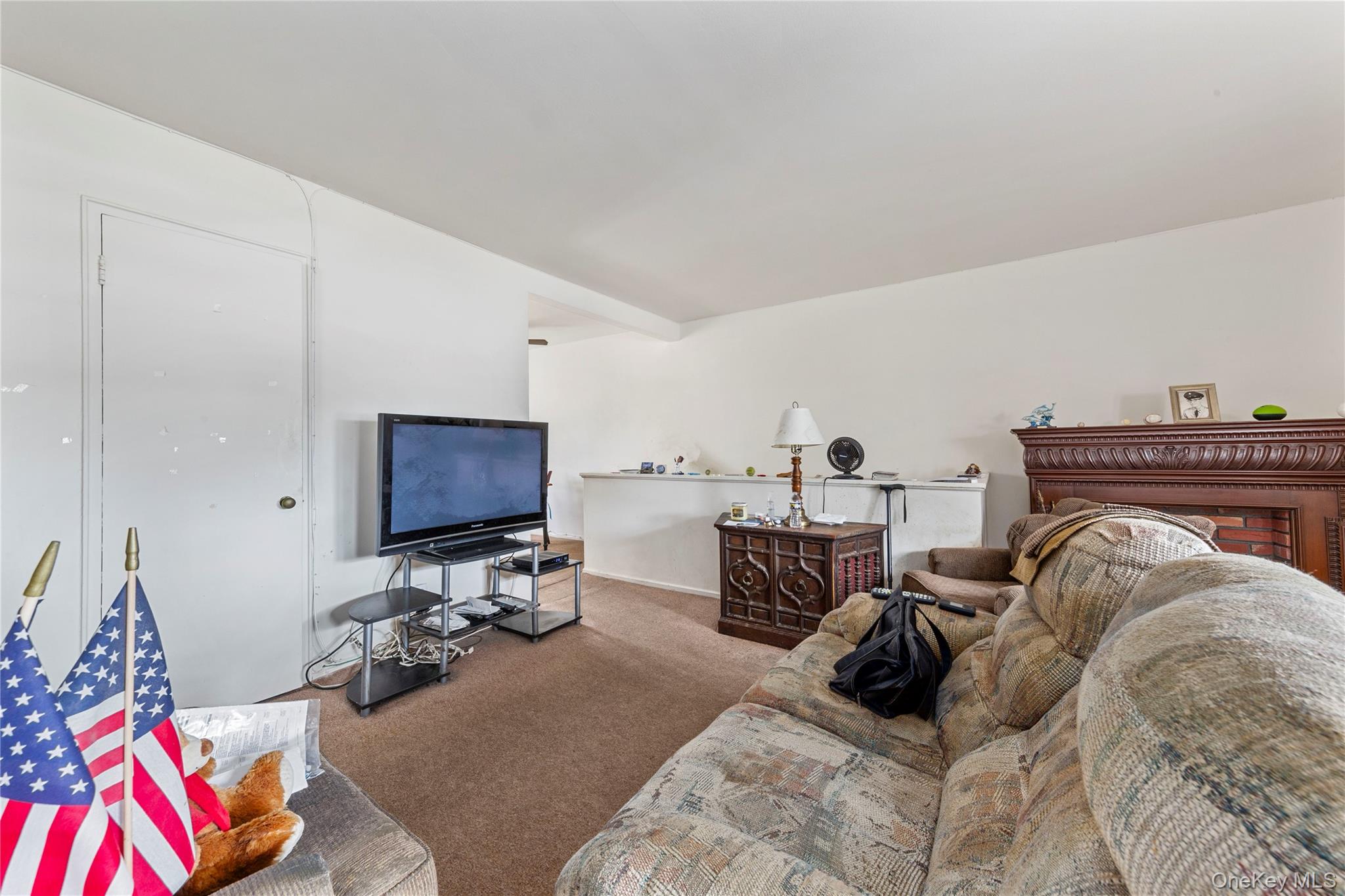 221-31 Braddock Avenue, Unit UPPR Queens, NY 11427 - Photo 3 of 16 a bedroom with furniture and a flat screen tv