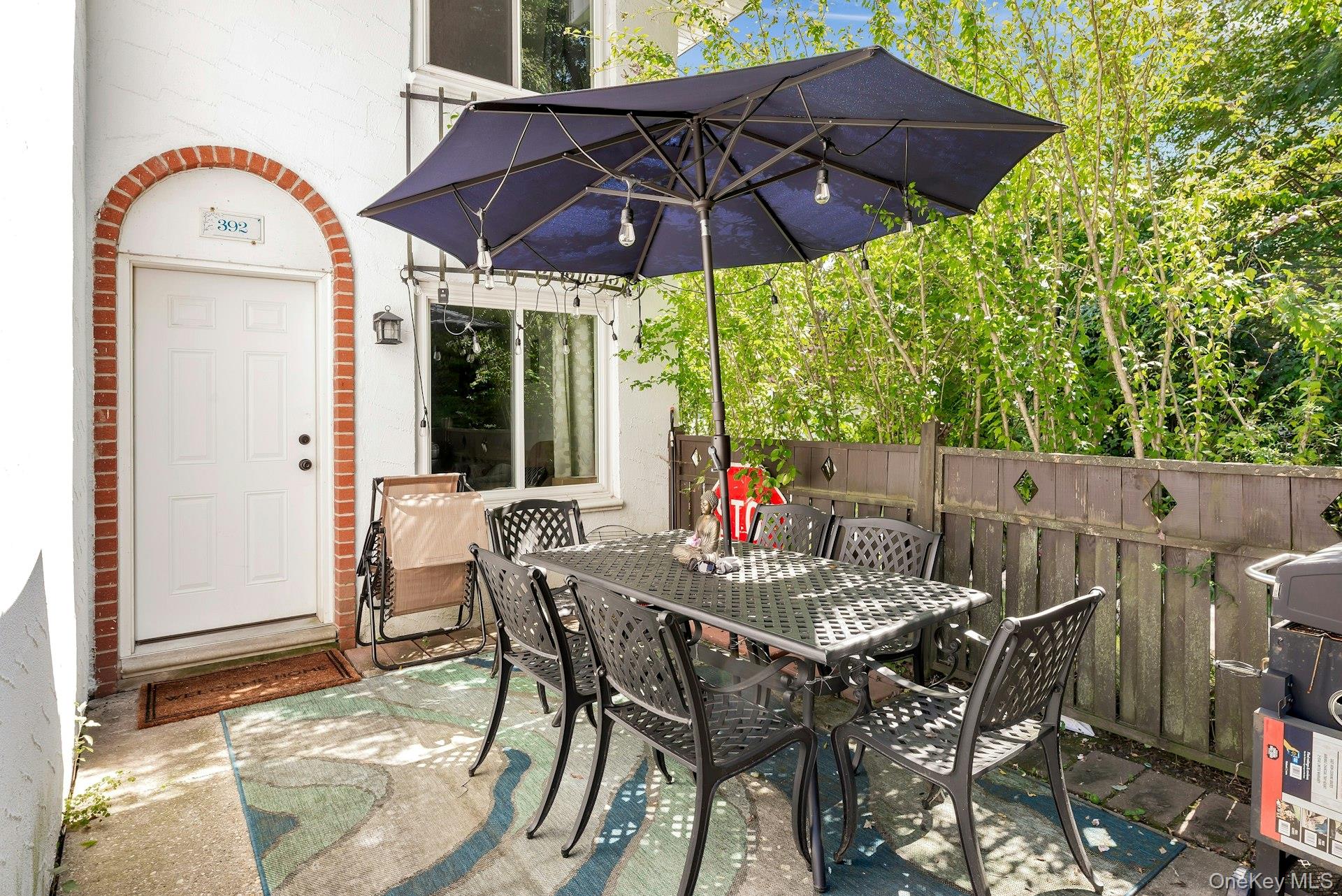 392 Birchwood Road Medford, NY 11763 - Photo 2 of 22 a view of a patio with table and chairs under an umbrella