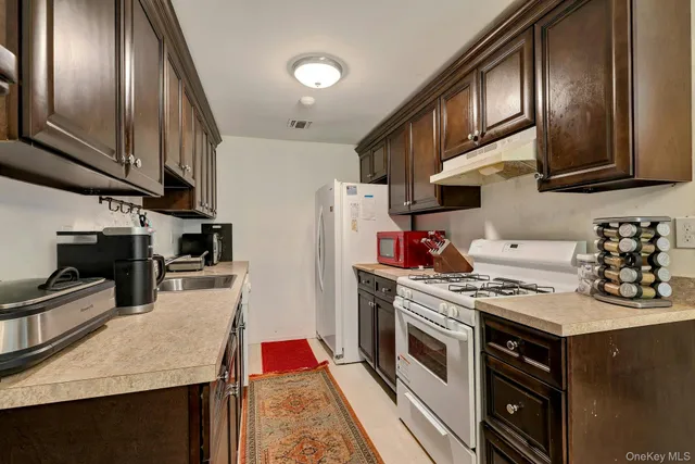 a kitchen with stainless steel appliances granite countertop a stove a sink dishwasher and a refrigerator