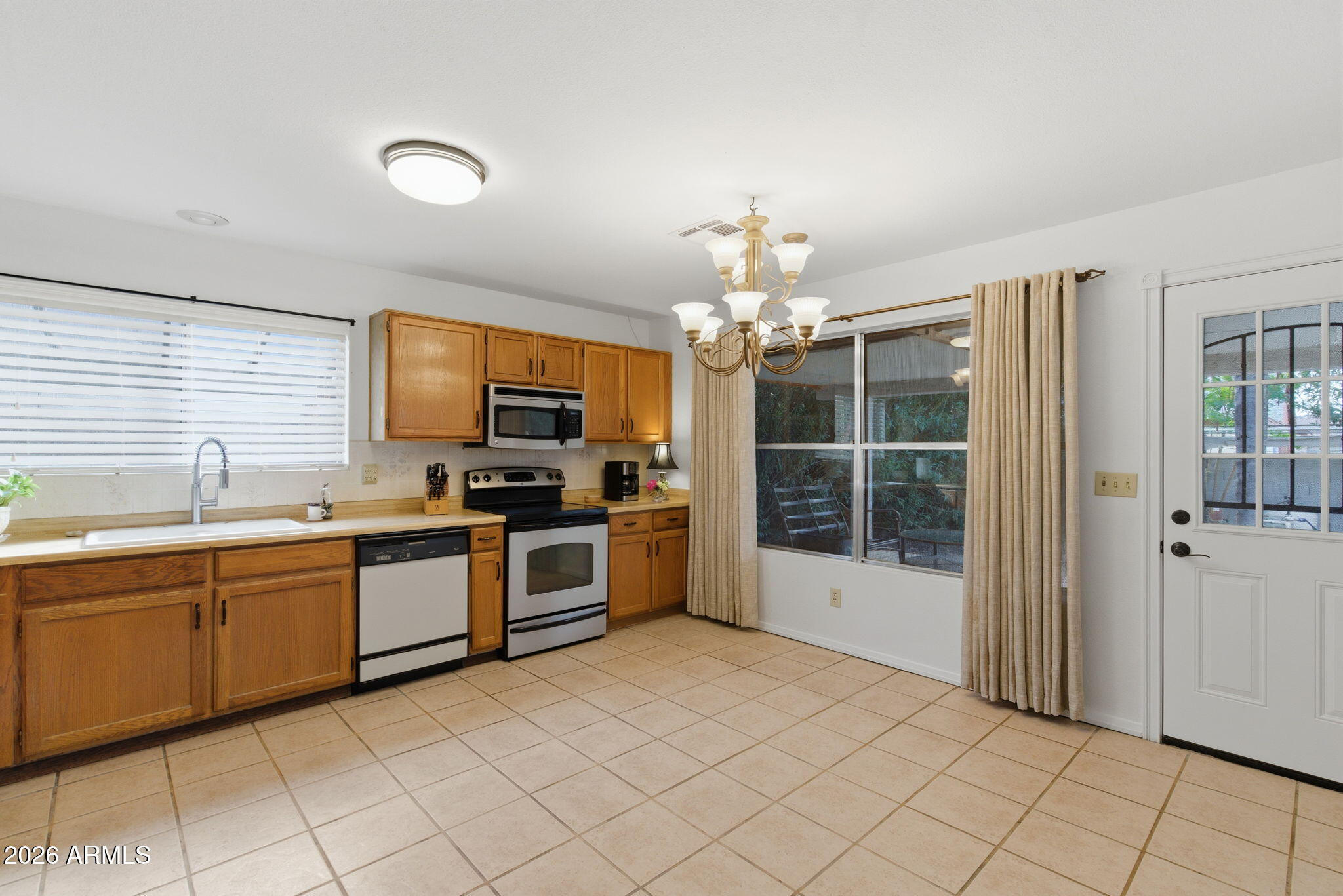 7119 West Ocotillo Road Glendale, AZ 85303 - Photo 11 of 24 a large kitchen with kitchen island granite countertop a sink window and stainless steel appliances