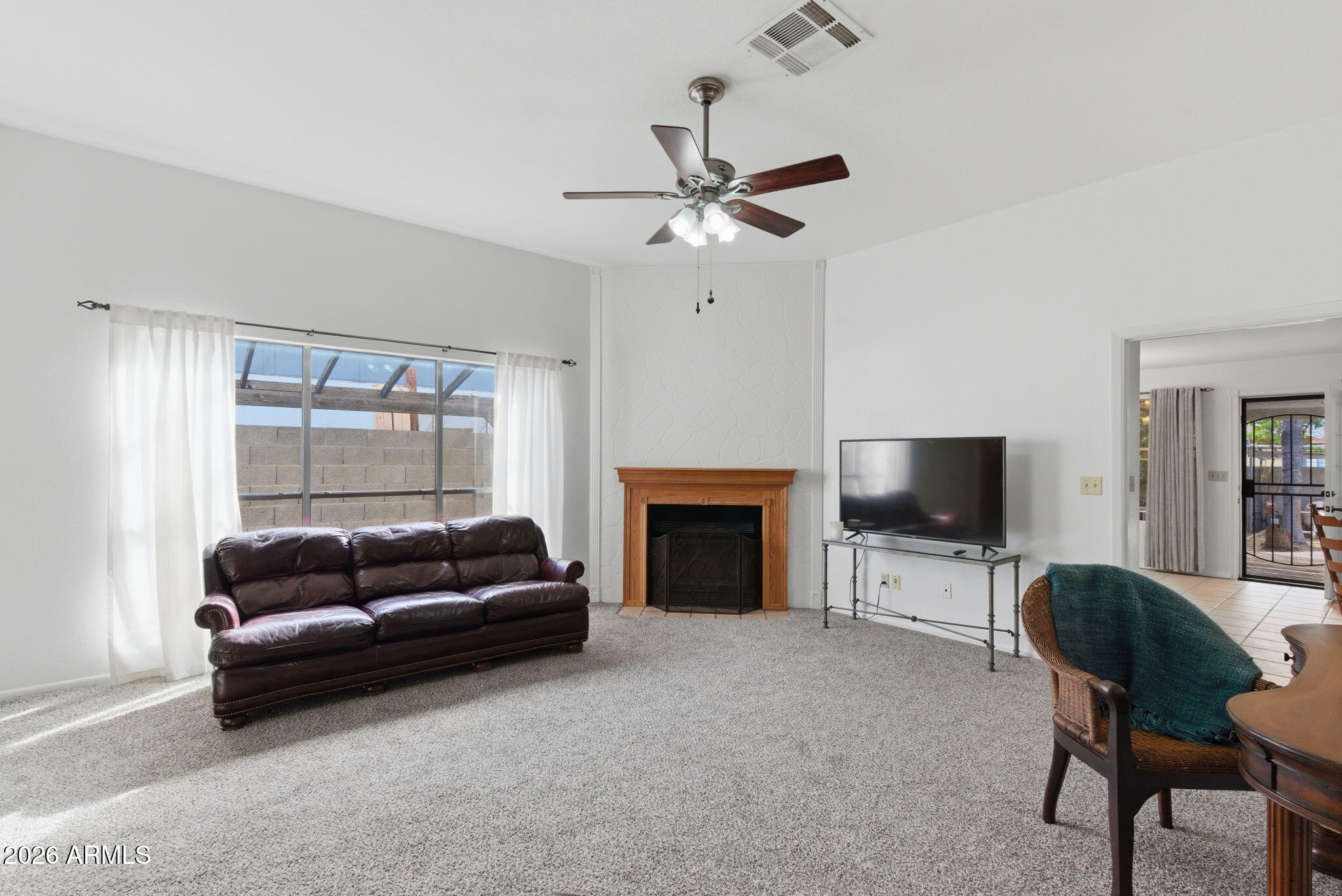 7119 West Ocotillo Road Glendale, AZ 85303 - Photo 3 of 24 a living room with furniture a fireplace and a flat screen tv
