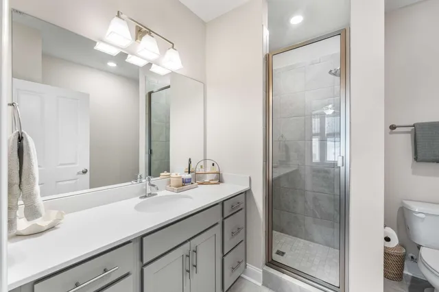 a bathroom with a sink a toilet and shower