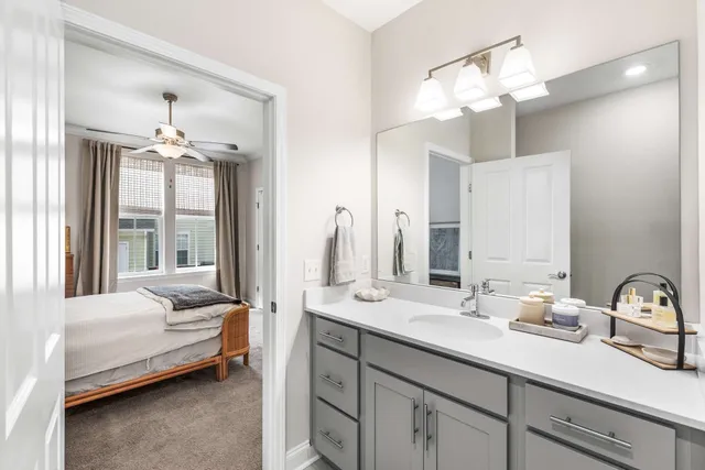 a en suite bathroom with a double vanity sink large mirror and chandelier