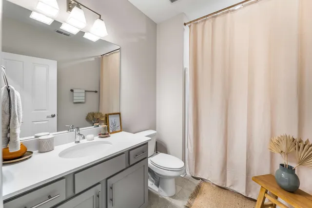 a bathroom with a sink a toilet and shower curtain
