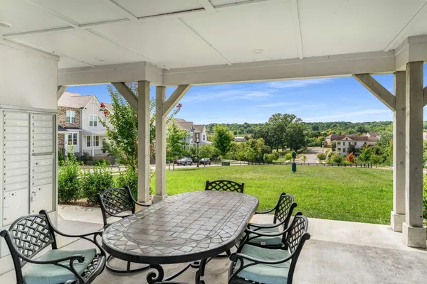 a view of a patio with a table chairs and a yard