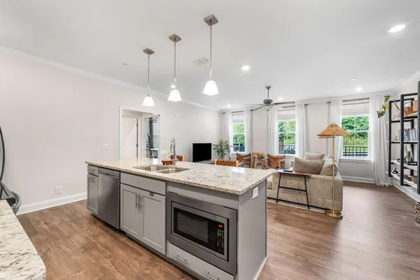 a kitchen with stainless steel appliances granite countertop a stove a sink and a wooden floors