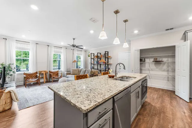 a open kitchen with stainless steel appliances granite countertop a stove and granite countertops with wooden floor