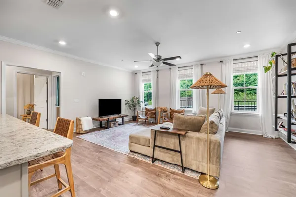 a living room with furniture a flat screen tv and a large window