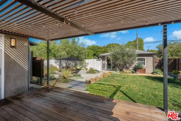 a view of a patio with table and chairs under an umbrella