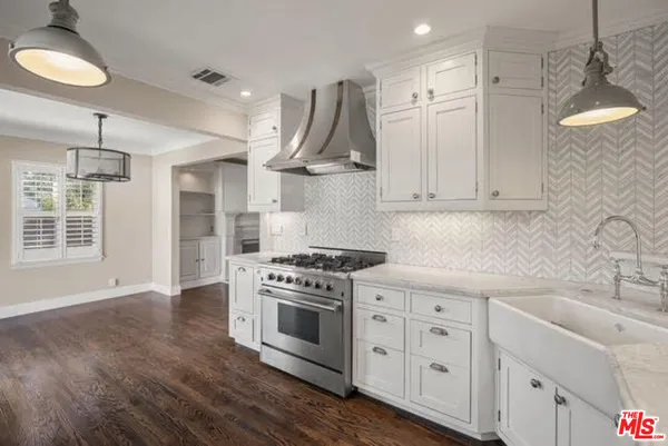 a kitchen with stainless steel appliances a stove a sink and cabinets