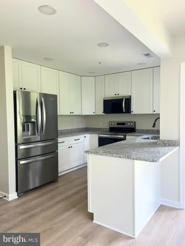 a kitchen with stainless steel appliances granite countertop a refrigerator stove a sink and a microwave