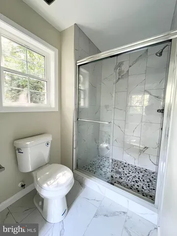 a bathroom with a toilet and a shower