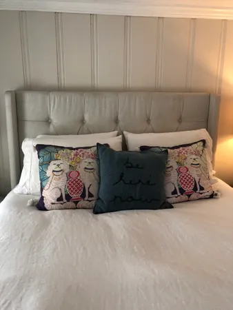 a bedroom with a bed and a lamp on dresser