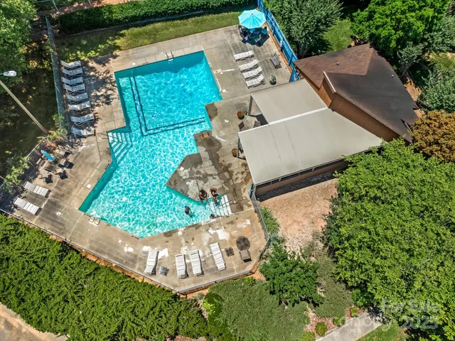 an aerial view of a house with a yard and large trees