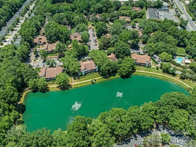 an aerial view of residential houses with outdoor space and trees all around