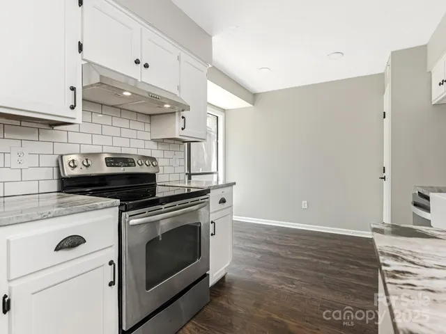 a kitchen with stainless steel appliances granite countertop a stove and a refrigerator