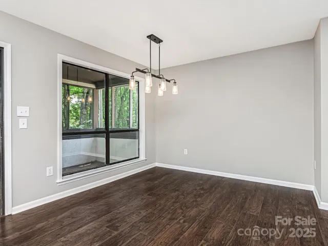a view of a room with wooden floor large window and outdoor space