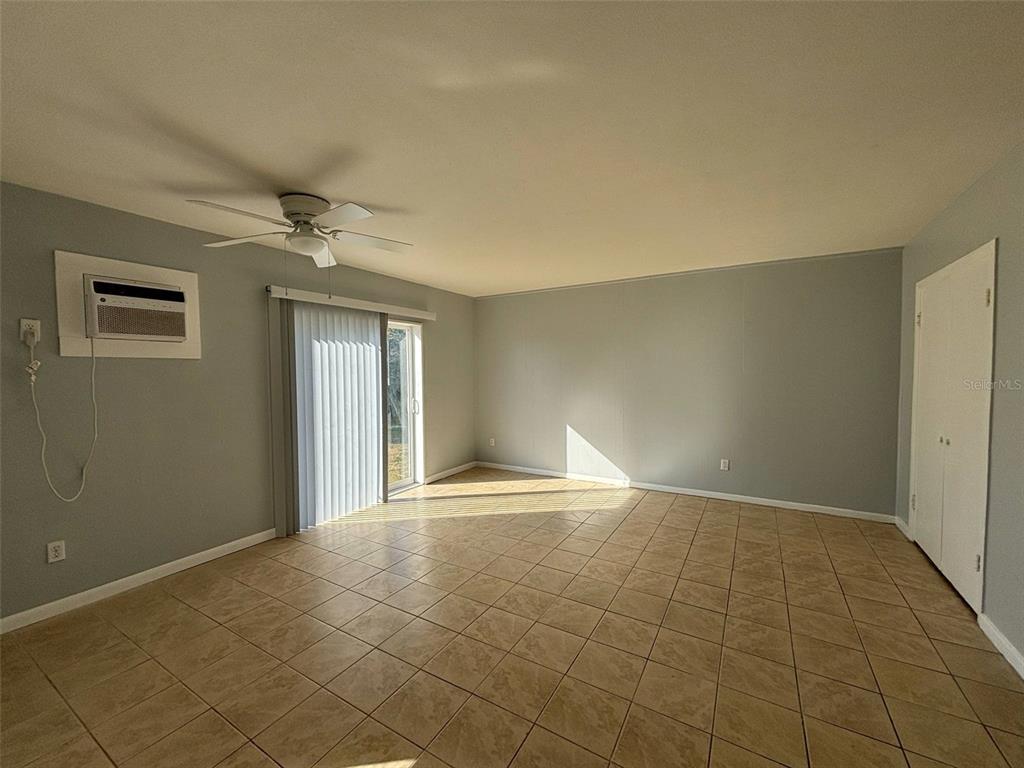310 Farnol Street Southwest, Unit 3 Winter Haven, FL 33880 - Photo 5 of 9 a view of an empty room with window and chandelier fan