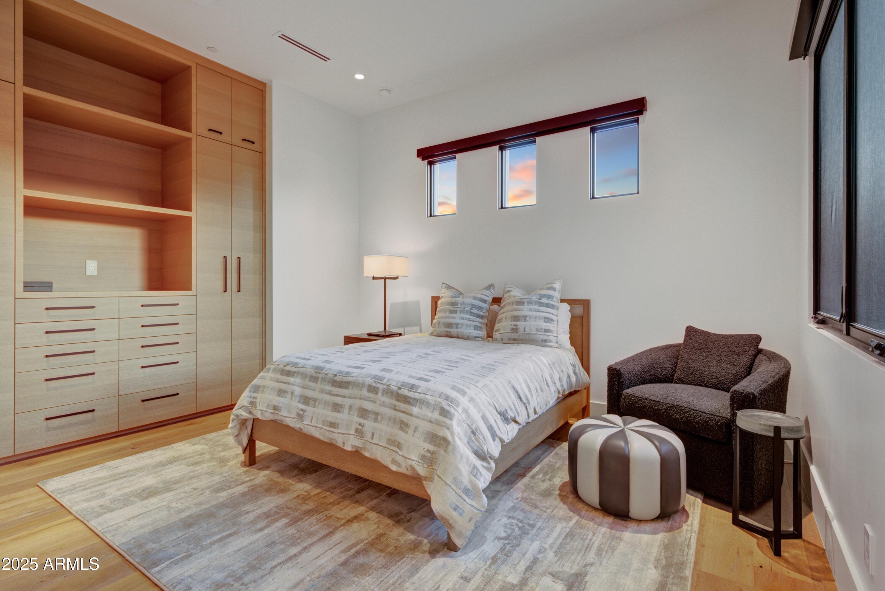 6930 East Cactus Wren Road Paradise Valley, AZ 85253 - Photo 20 of 26 a bedroom with a bed and wooden floor