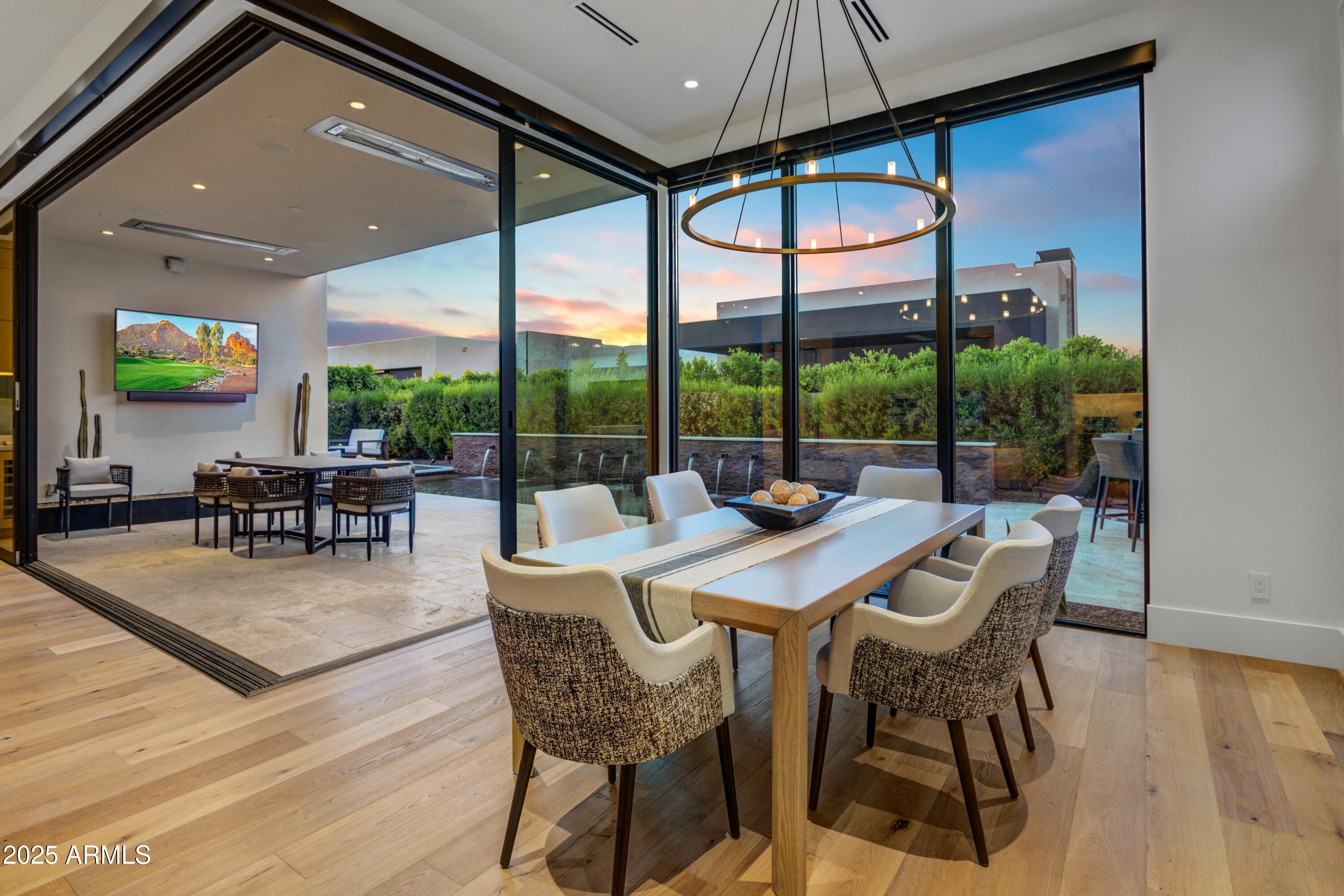 6930 East Cactus Wren Road Paradise Valley, AZ 85253 - Photo 6 of 26 a view of a dining room with furniture wooden floor and chandelier